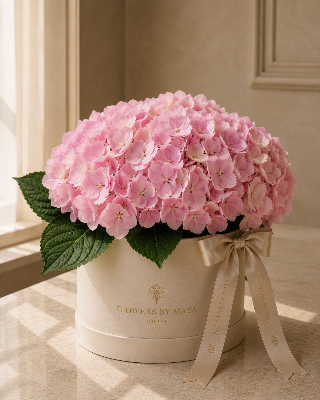 Pink Hydrangea Hat Box by Flowers By Maya, full pink hydrangea heads in a cream suede hat box with champagne ribbon
