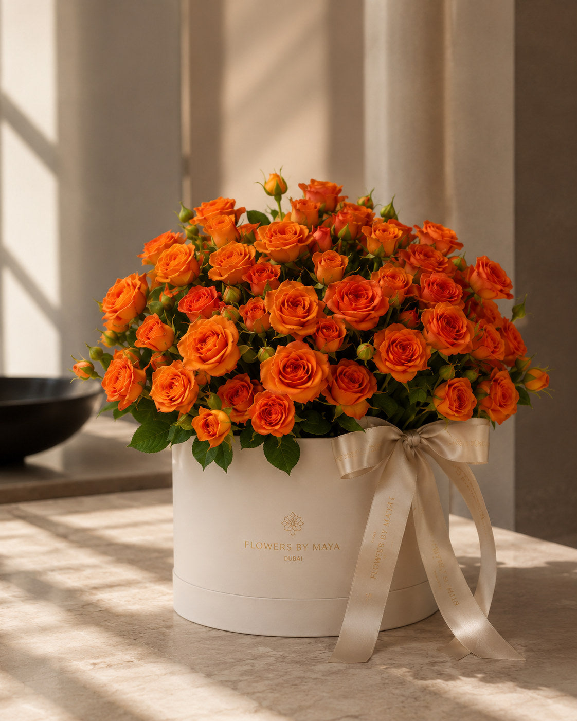 Tangerine Spray Rose Hat Box by Flowers By Maya, deep orange spray roses packed in a cream suede hat box