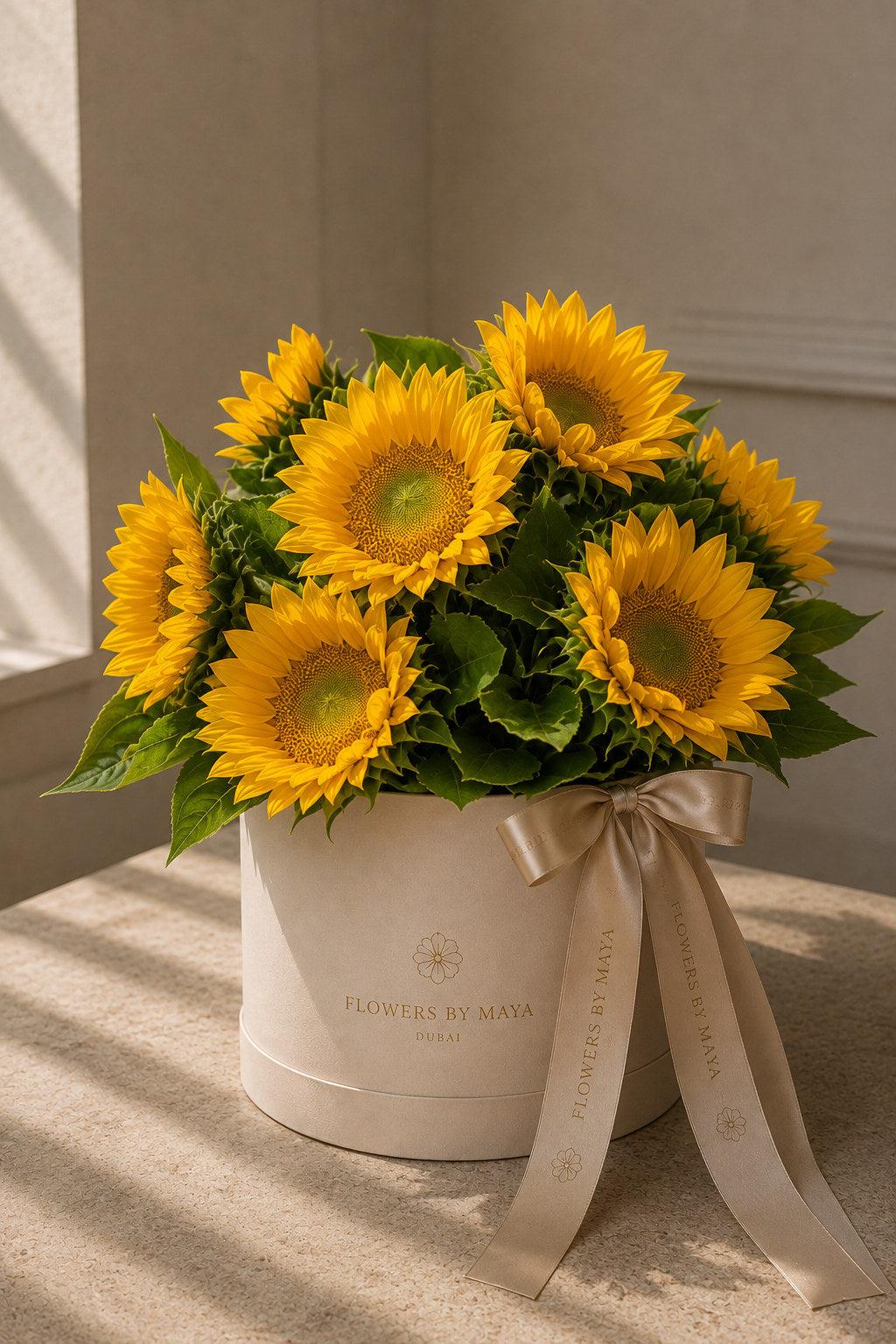 Sunflower Hat Box by Flowers By Maya, golden sunflowers with green foliage in a cream suede hat box