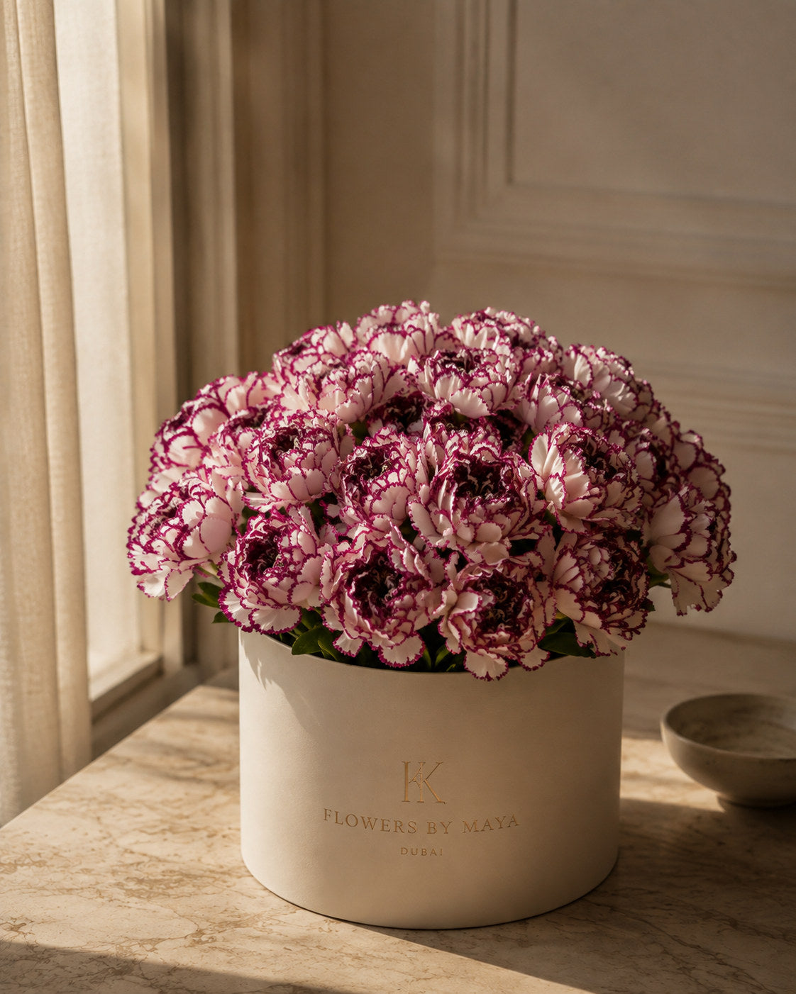 Burgundy Picotee Carnation Hat Box by Flowers By Maya, pink carnations with deep burgundy edged petals in a cream suede hat box